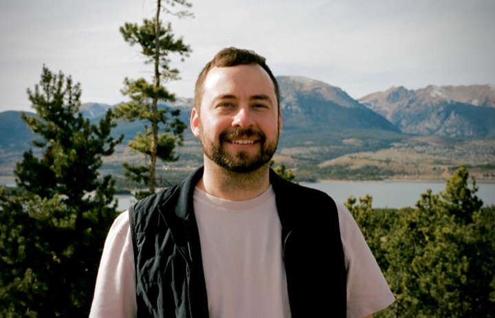 Mark Hopper outdoors with mountains behind him